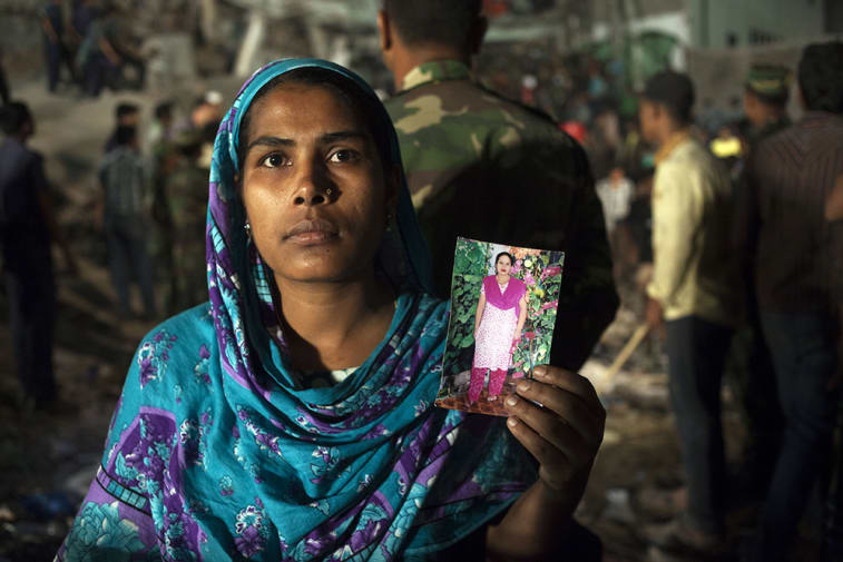 A-woman-holding-a-picture-of-her-missing-relative–at-the-collapse-site—-