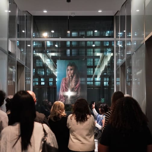 An image of multiple people looking at a piece of art 