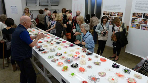 Group of people looking at art displayed on a table