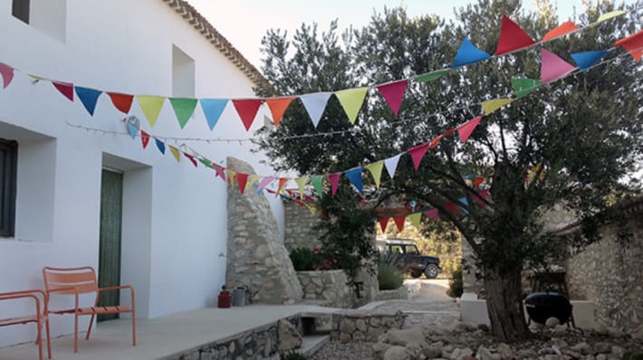 Photo of a white house with colourful bunting hanging outside