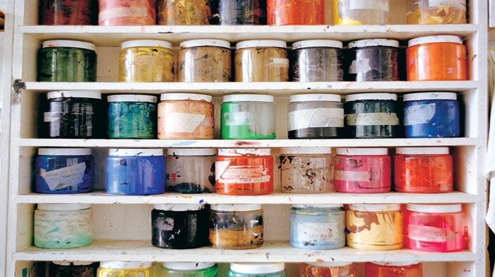 Shelves of coloured paint pots