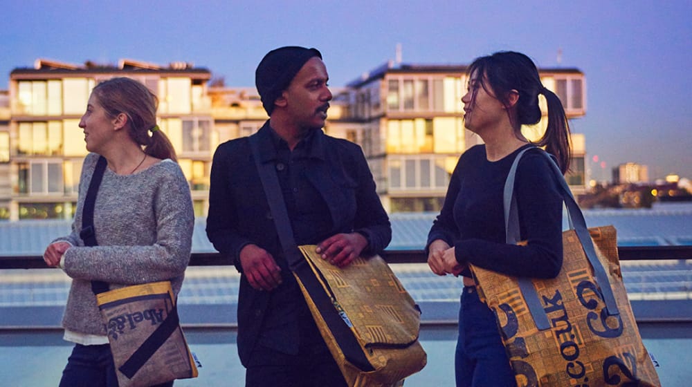 Three people standing by the river