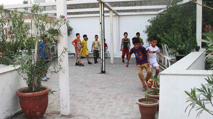 Photo of a group of young boys playing football in a courtyard