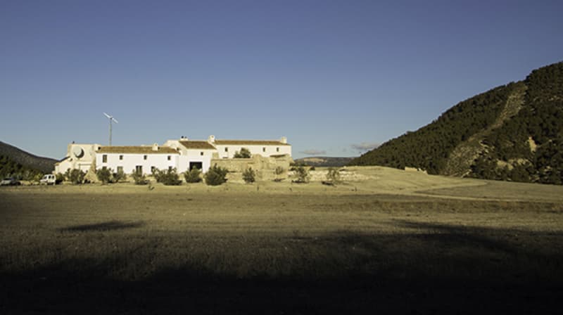 Photo of a large white house in between two hills