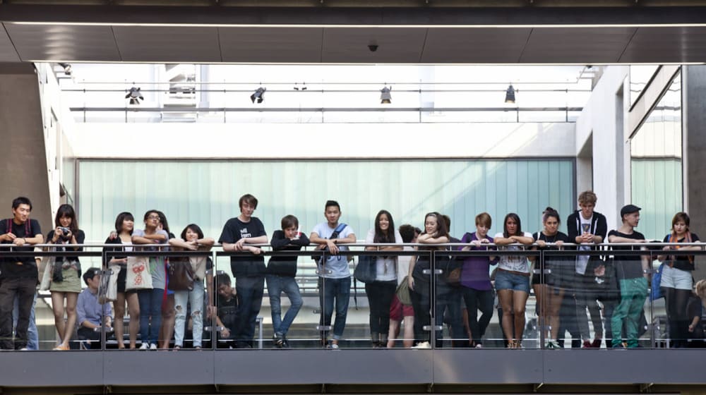 A row of people stood on the top floor inside Central Saint Martins