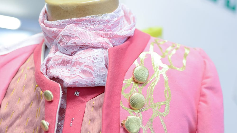 Close up shot of a pink dress coat with gold trim