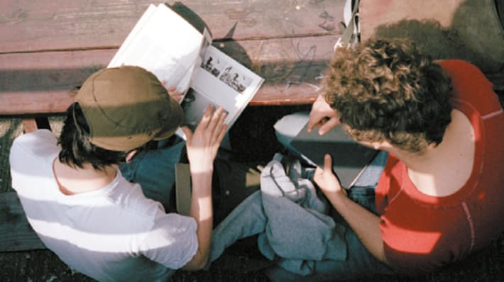 Two students reading reference books