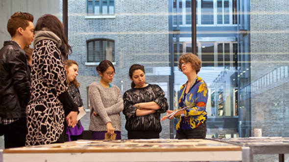 A group of people looking at someone holding a piece of paper