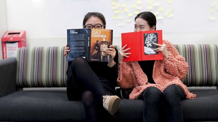 Two students holding books at LCC Library