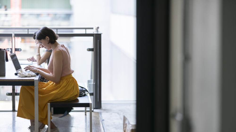 Student in yellow dress studying at a desk