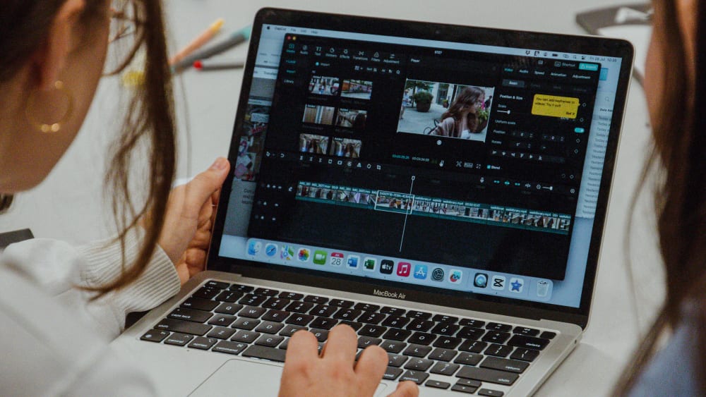 Students video editing on laptop