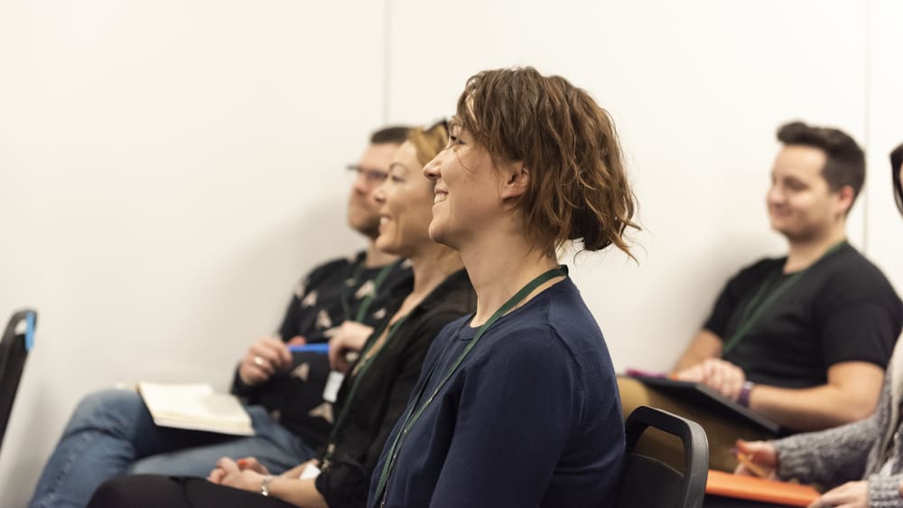 Woman laughing in audience at a conference