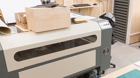 A large machine which has a wooden box on top of it