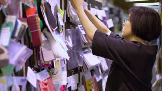A woman looking at materials hung on a wall