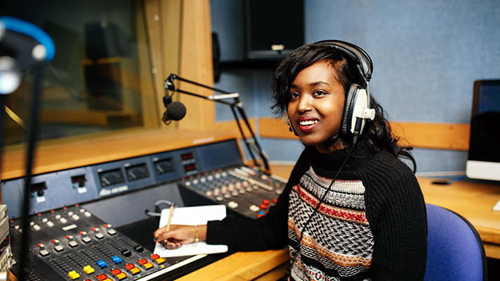 A journalism student working in one of the audio studios.