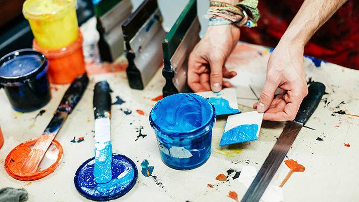 Hands using paint pots and brushes