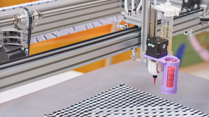 Detail image of a textile machine over a black and white material