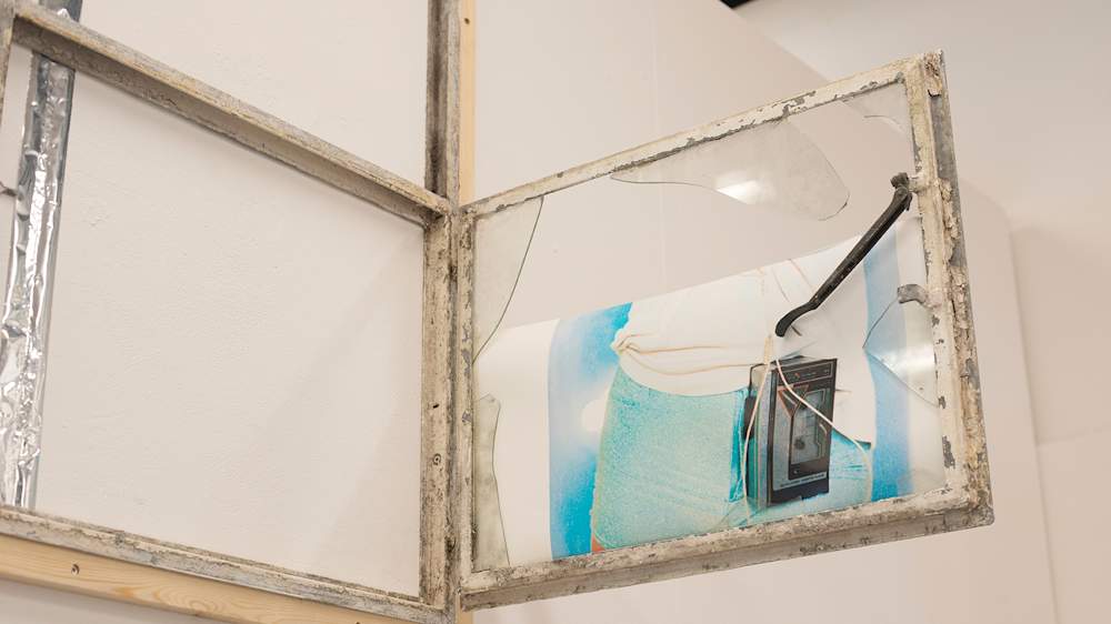 An artist installation featuring wooden frames, windows, MDF, photographic prints, vinyl, stereo. We see a cross section of a body wearing a cassette player.