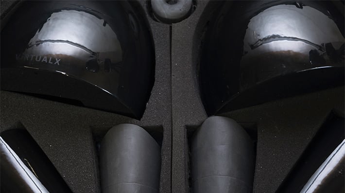 An open box which has a set of black plastic objects inside