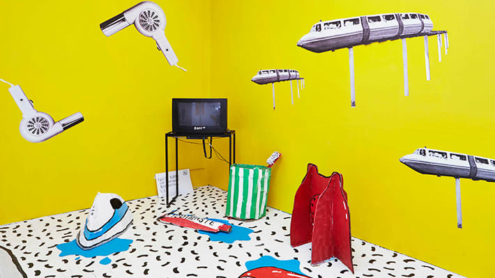 Yellow walls with the television on a table and objects in the air
