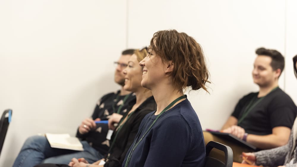 Woman laughing in audience at a conference