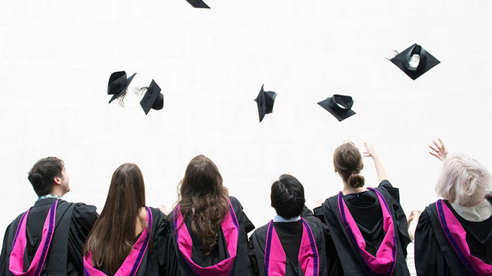 Students throwing mortar boards in the air