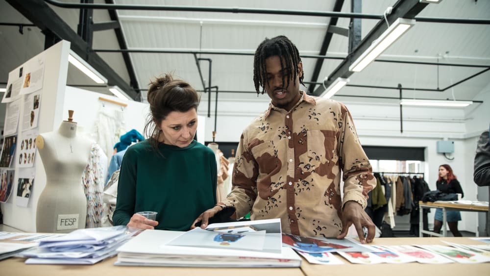 Student and tutor looking at student's fashion portfolio