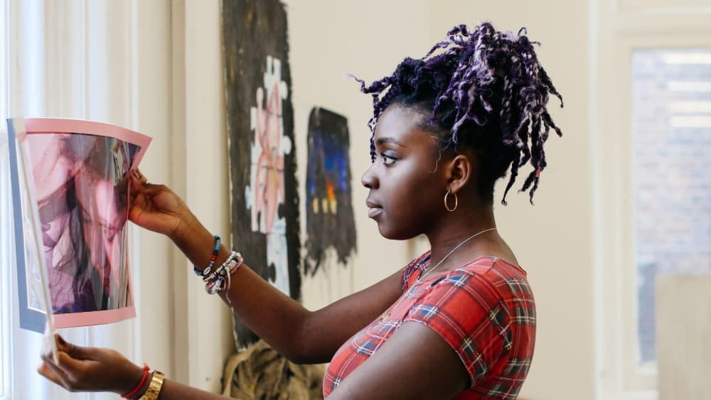 Student holding up artwork