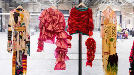 a window displaying 4 dresses