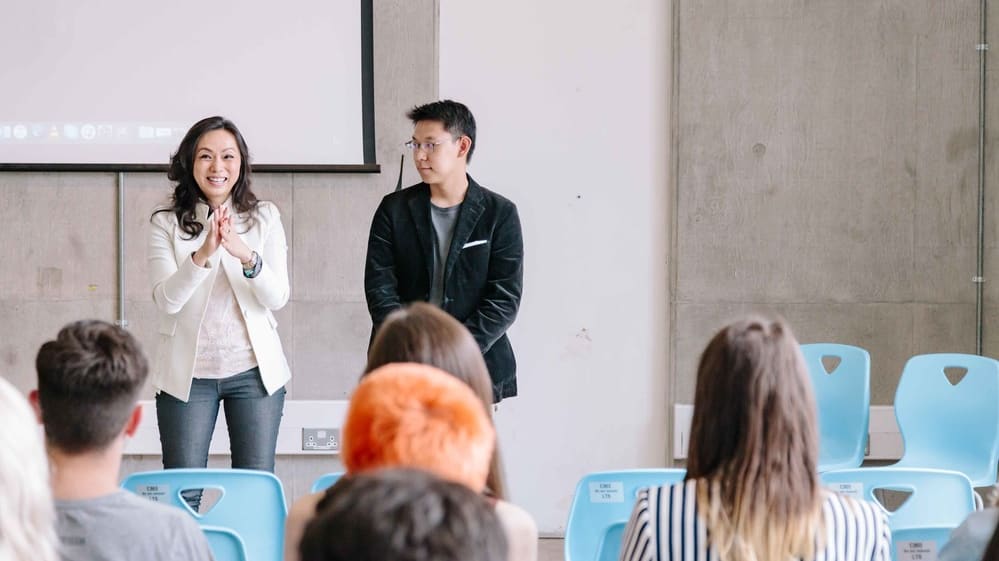 Man and woman speaking in front of an audience