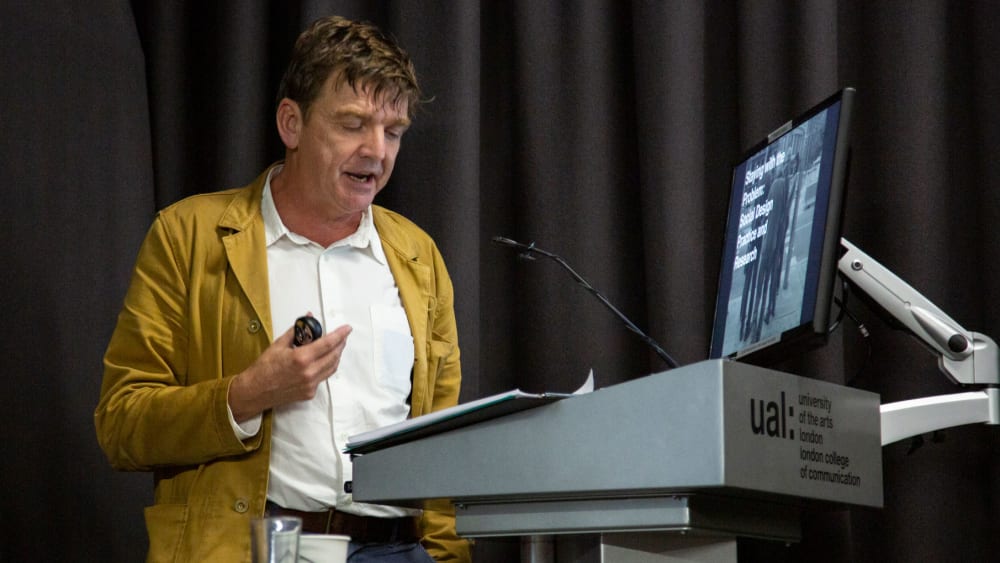 Professor Guy Julier at the podium delivering their lecture.