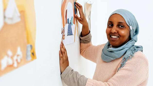 Student with art work on wall