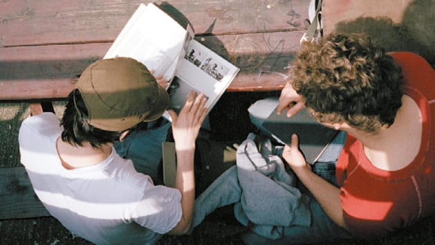 Two students reading reference books