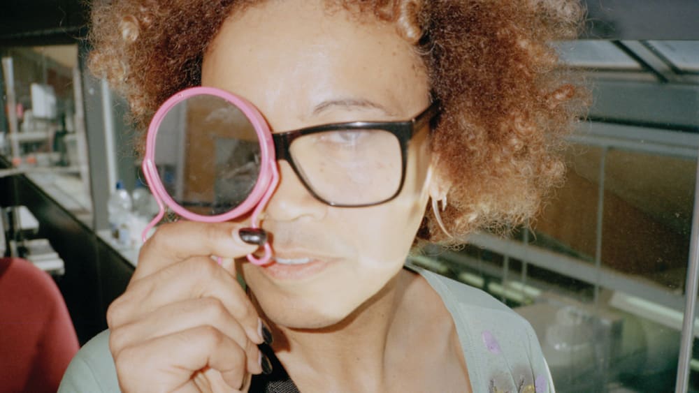 a person holds a mirror up to their eye