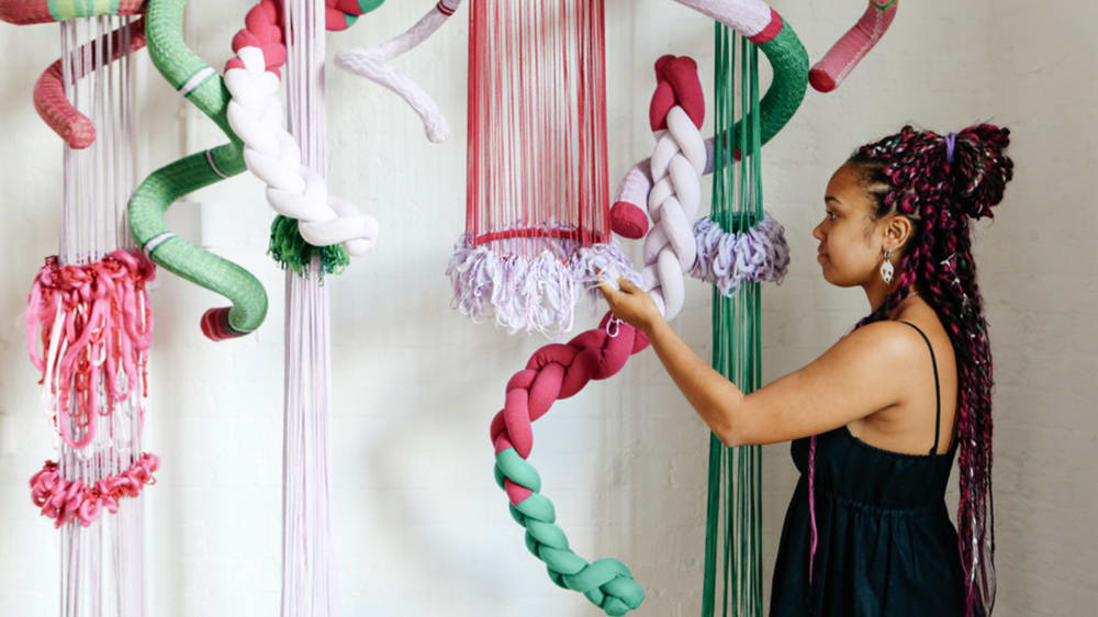 Students with hanging textiles installation