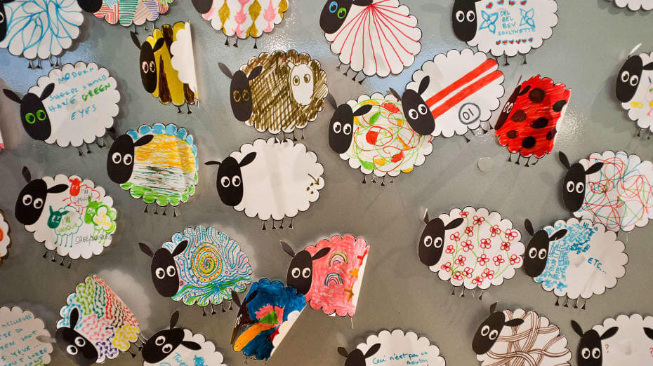 A series of illustrated sheep laid out on a table top