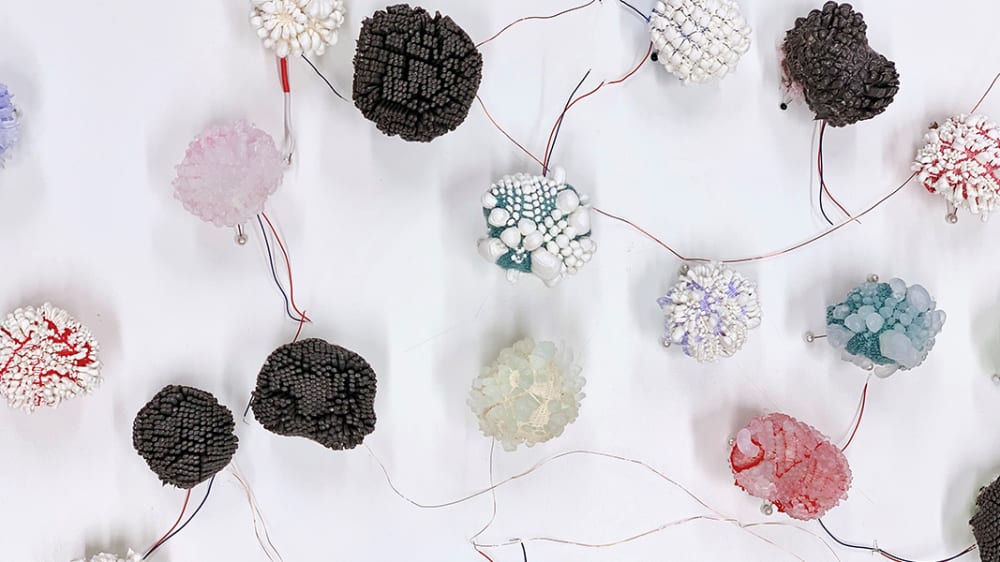 Closeup of pom poms on wires