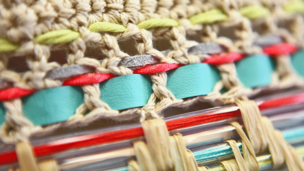 Plaited string with pieces of red and turquoise material woven through