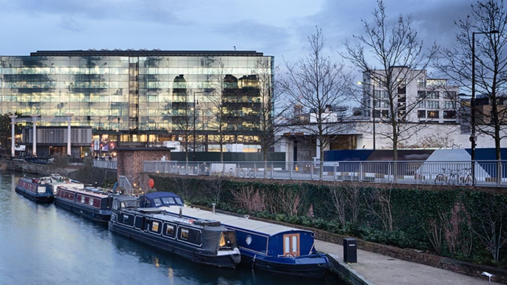 A large glass building opposite Regent's Canal