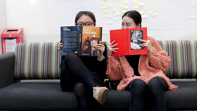 Two students holding books at LCC Library