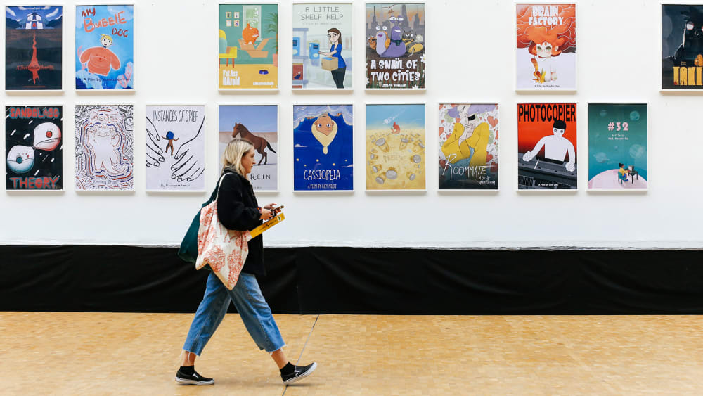 Student walking along a corridor with animated posters on the wall