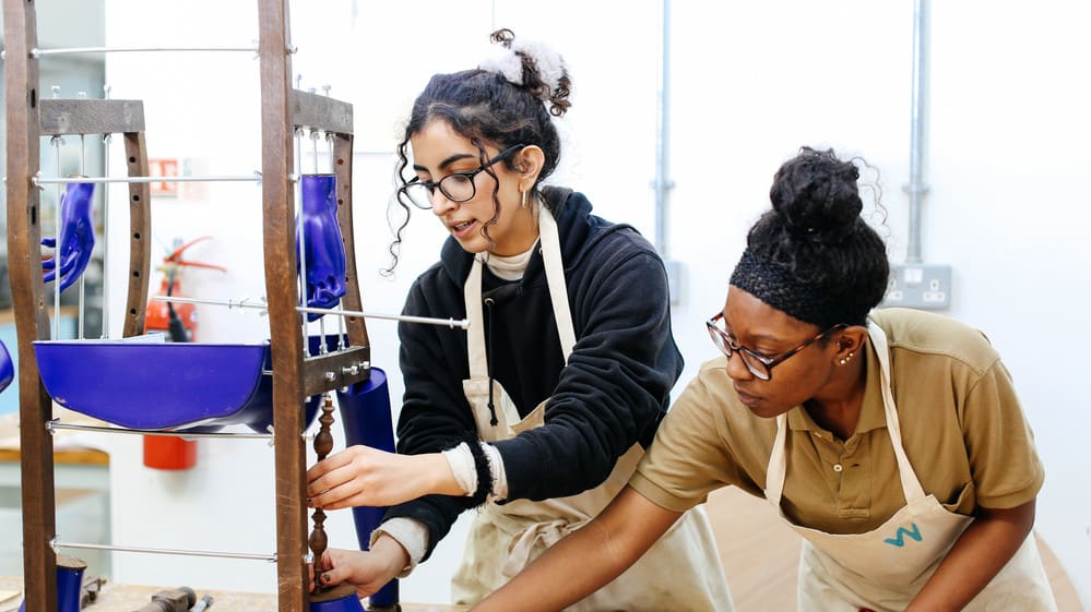 Two students creating a wooden structure