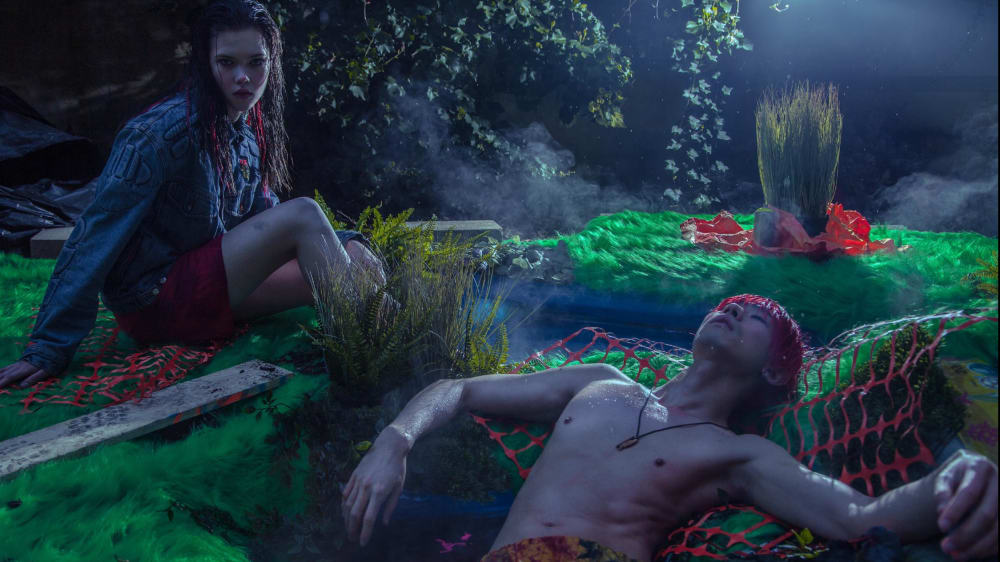 Two models posing in a decorated swamp