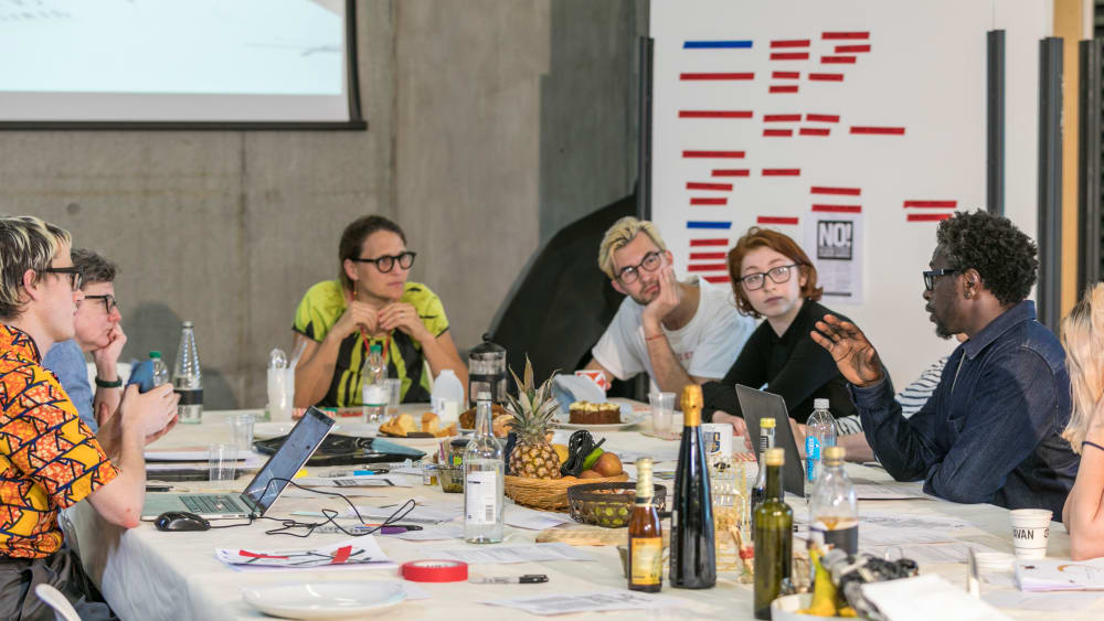 People sat around a table having a discussion
