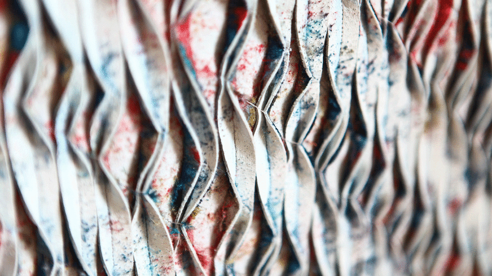 Folded pieces of material in white with splashes of colour