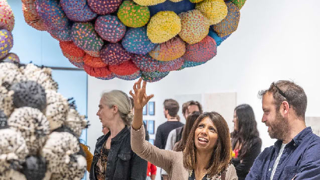 two people look at object hanging from ceiling