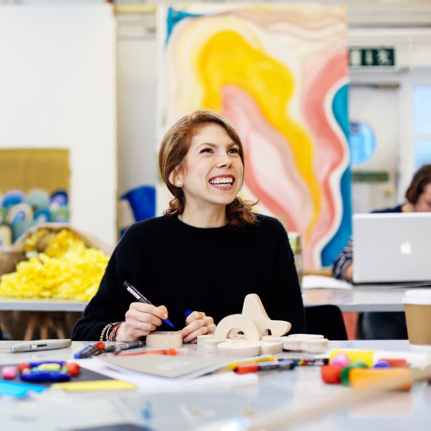 A person smiling while working in a studio.