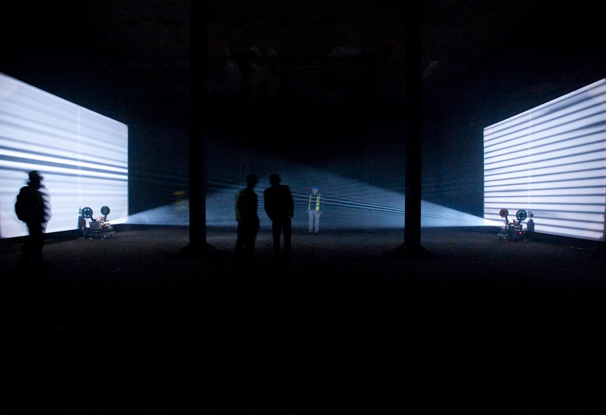 People in hi vis jackets watching a light installation