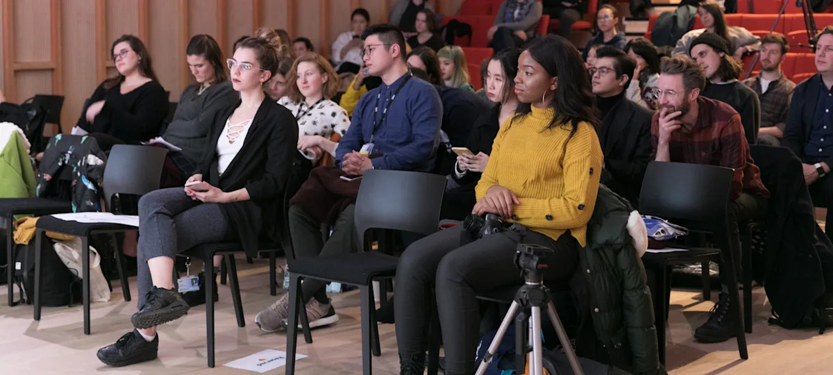 a group of people sitting on chairs listening to a seminar