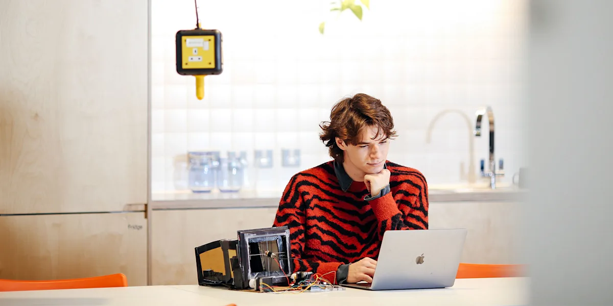 Student sat at a table working on their computer